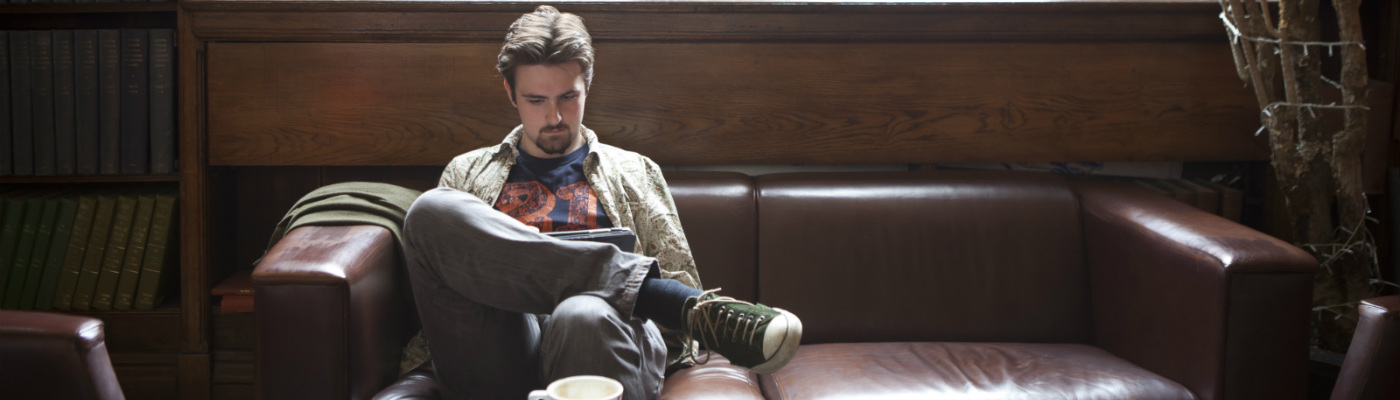 male on sofa with tablet